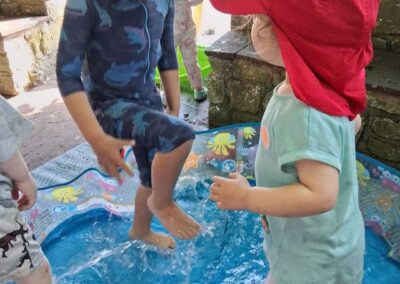 Little Woodlands Day Nursery. Outdoor water play and teamwork.